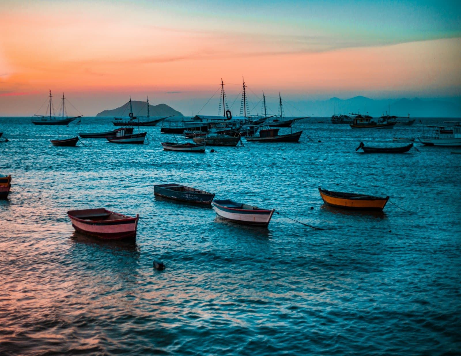 Fishing boats on turquoise water at golden hour in Búzios
