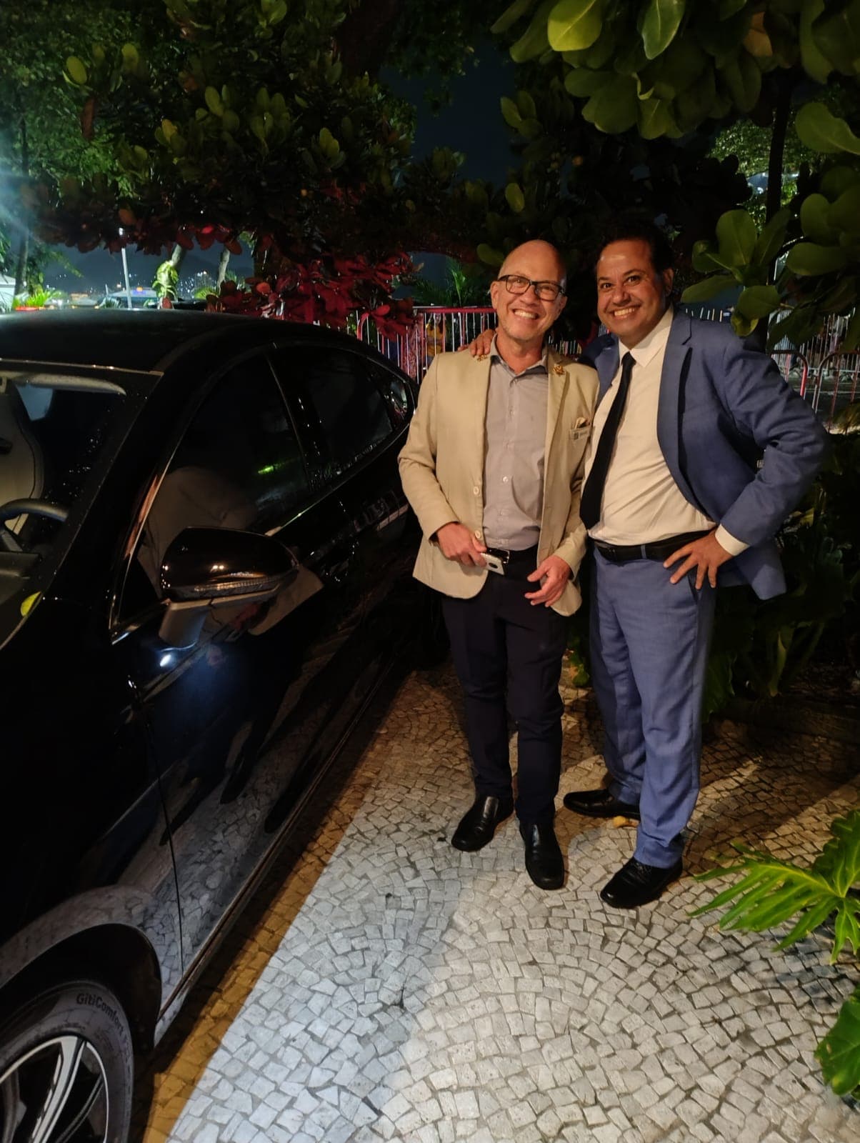 Mohammed with a guest beside the car in Copacabana, Rio de Janeiro, at night